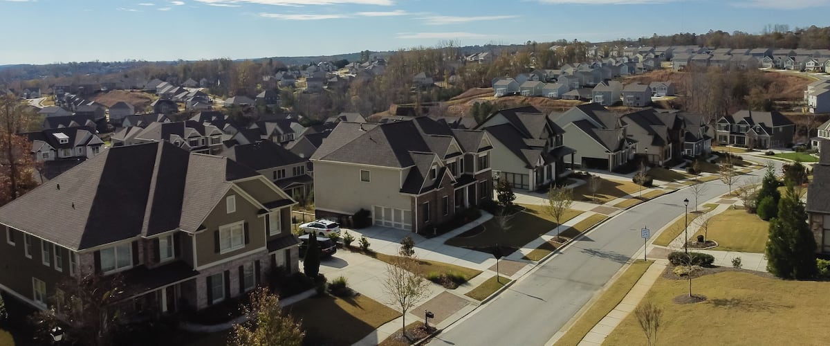 A suburban neighborhood with houses, streets, and a clear sky.