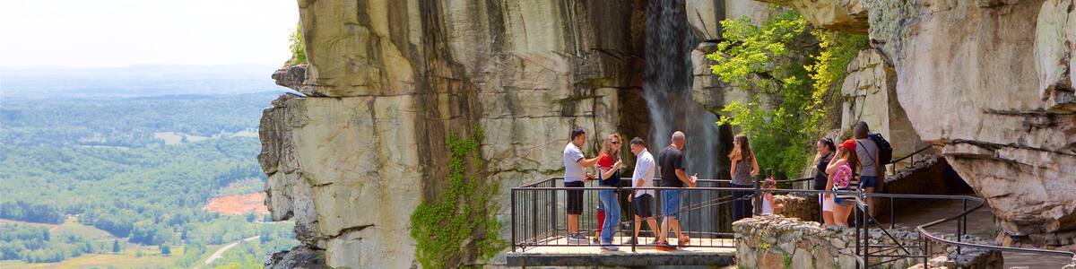 A stone bridge with a waterfall and a scenic view of the landscape.