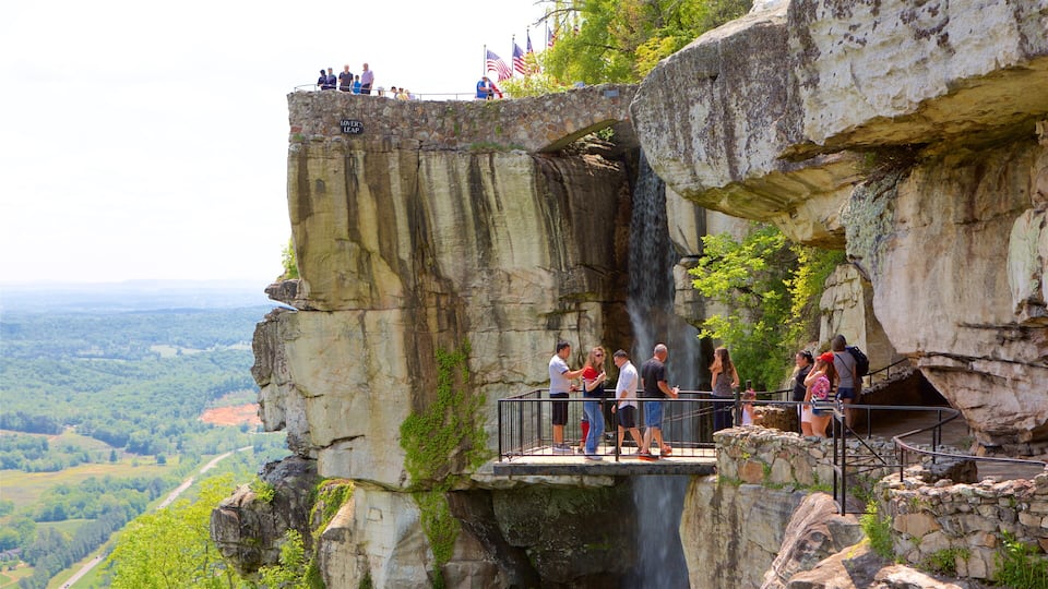 A stone bridge with a waterfall and a scenic view of the landscape.