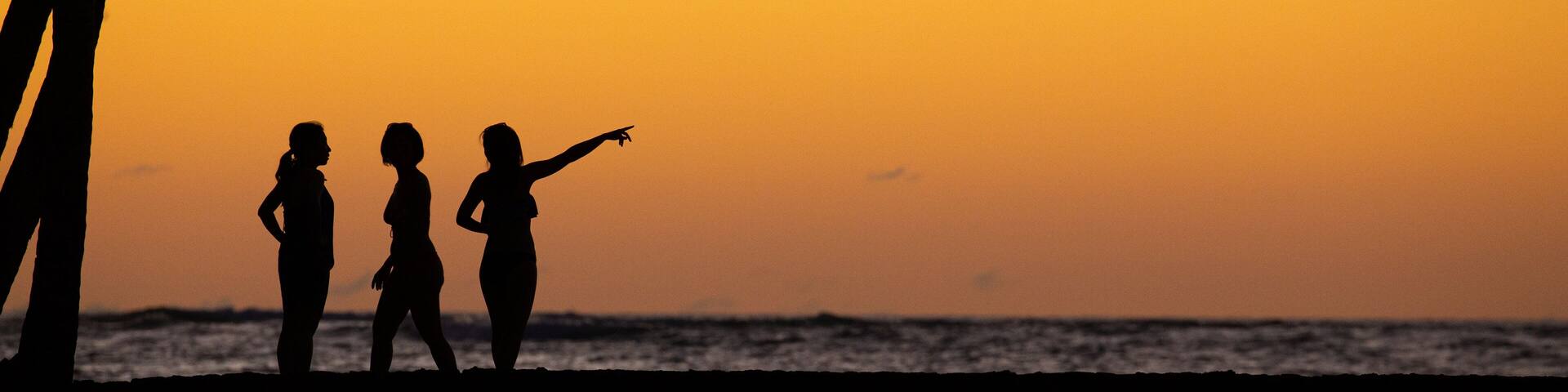 Waikoloa showing general coastal views and a sunset as well as a small group of people