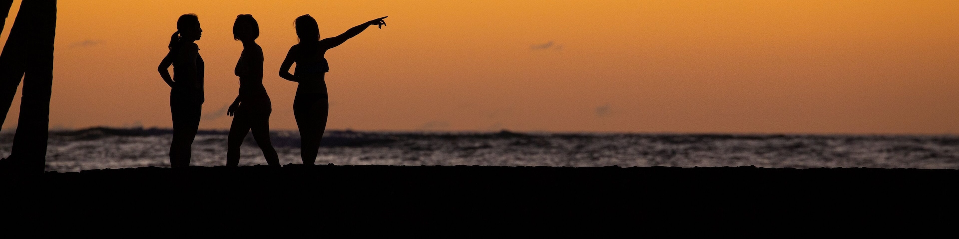 Waikoloa showing general coastal views and a sunset as well as a small group of people