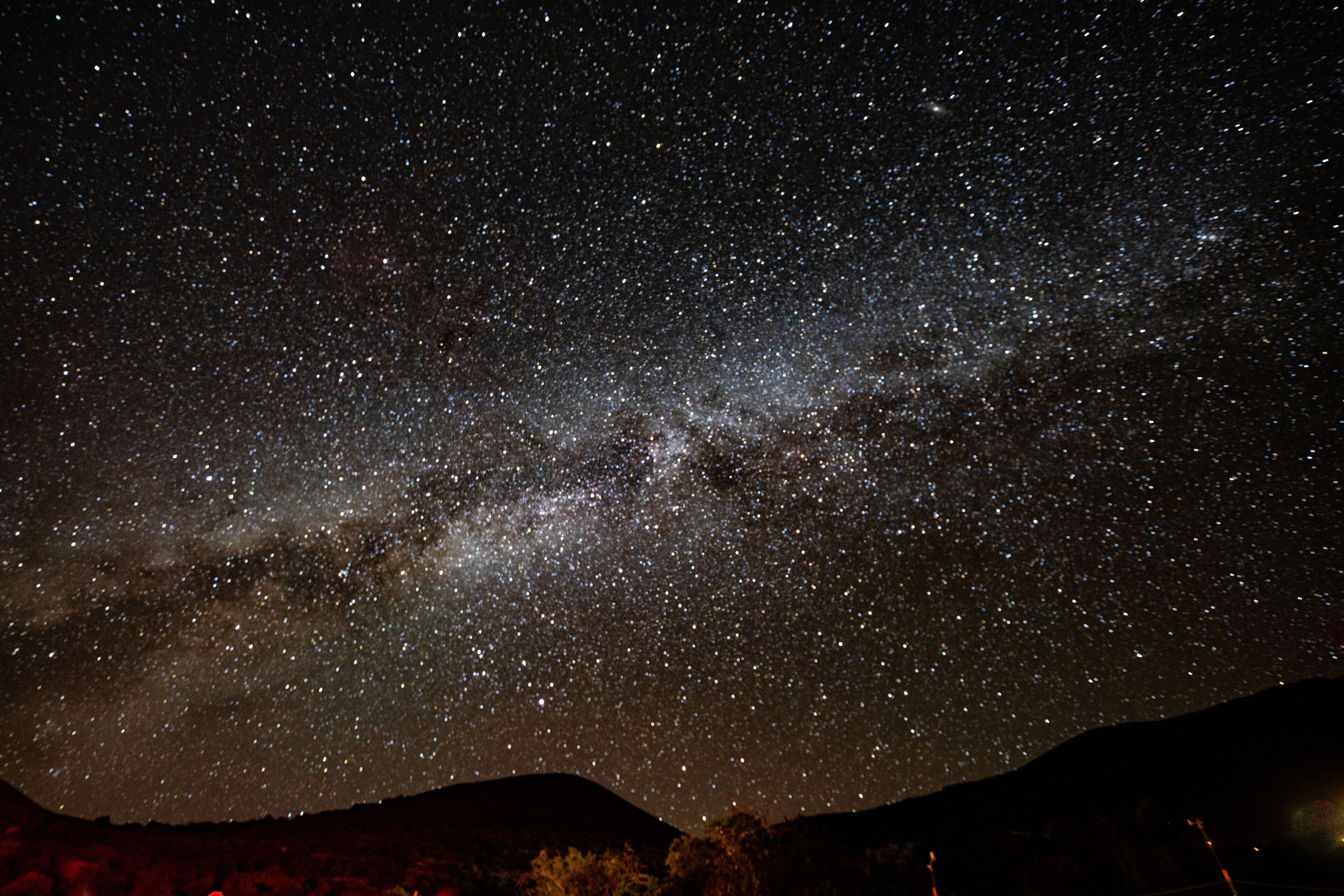A starry night sky over a mountainous landscape.