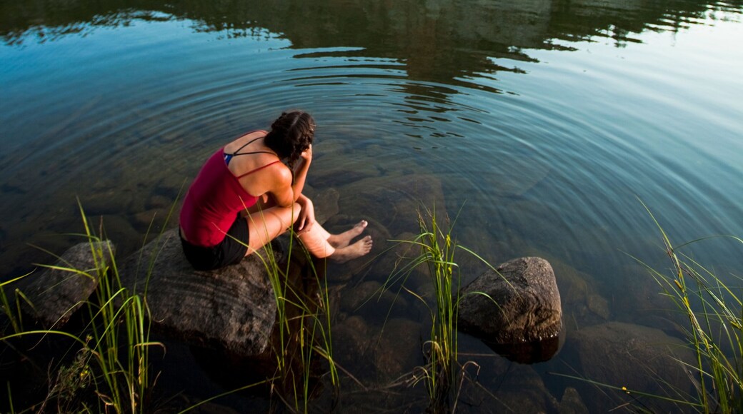 A woman soaks up the alpine bliss while sitting at Hatchett Lake afer a long day of backpacking in the White Cloud Mountains in Idaho.