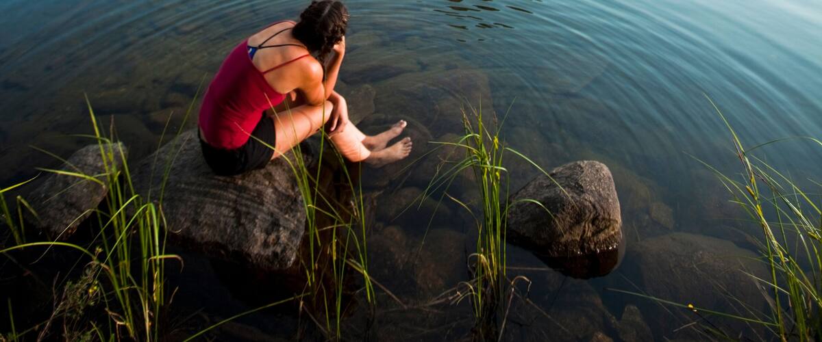 A woman soaks up the alpine bliss while sitting at Hatchett Lake afer a long day of backpacking in the White Cloud Mountains in Idaho.