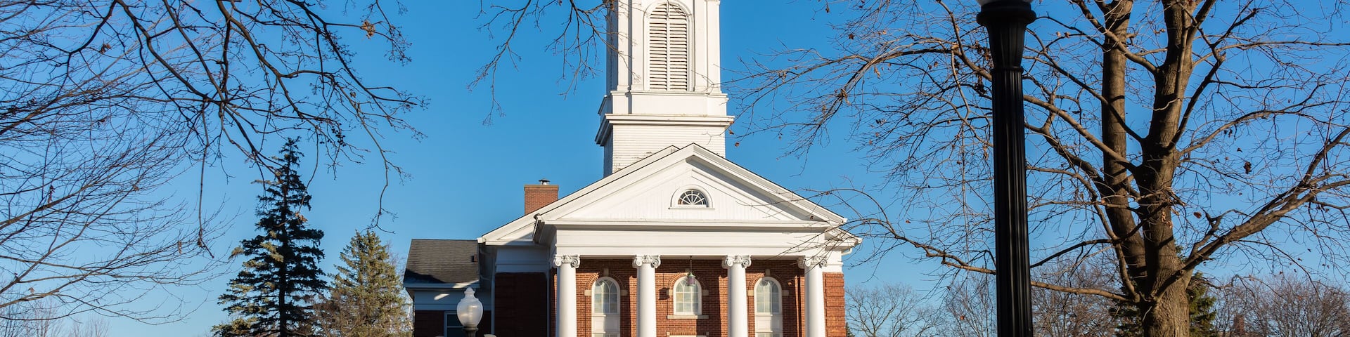 A church with a tall steeple and a brick facade.