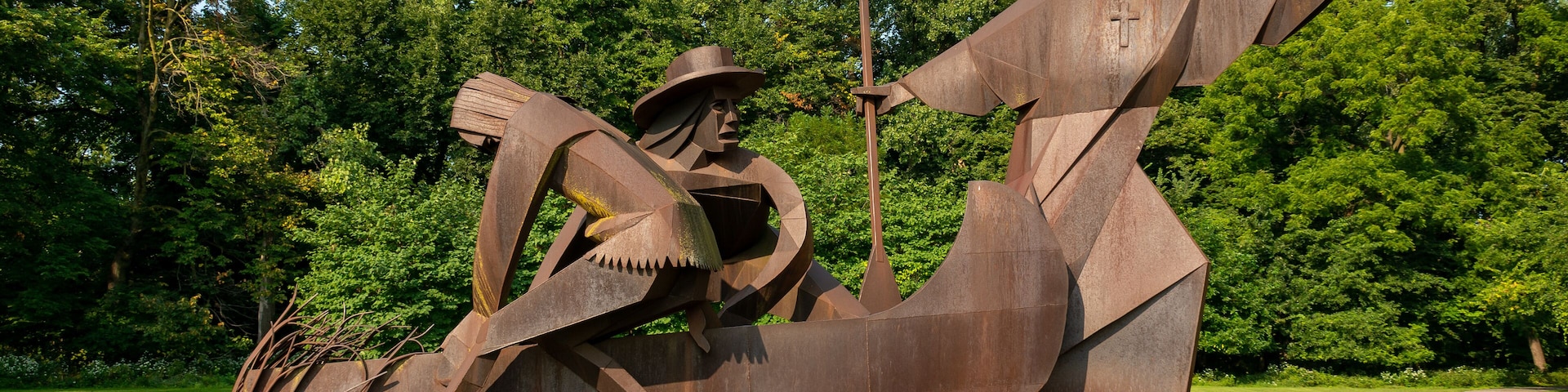 Una gran estatua de bronce de un hombre nativo americano en una canoa, con una placa en la base.