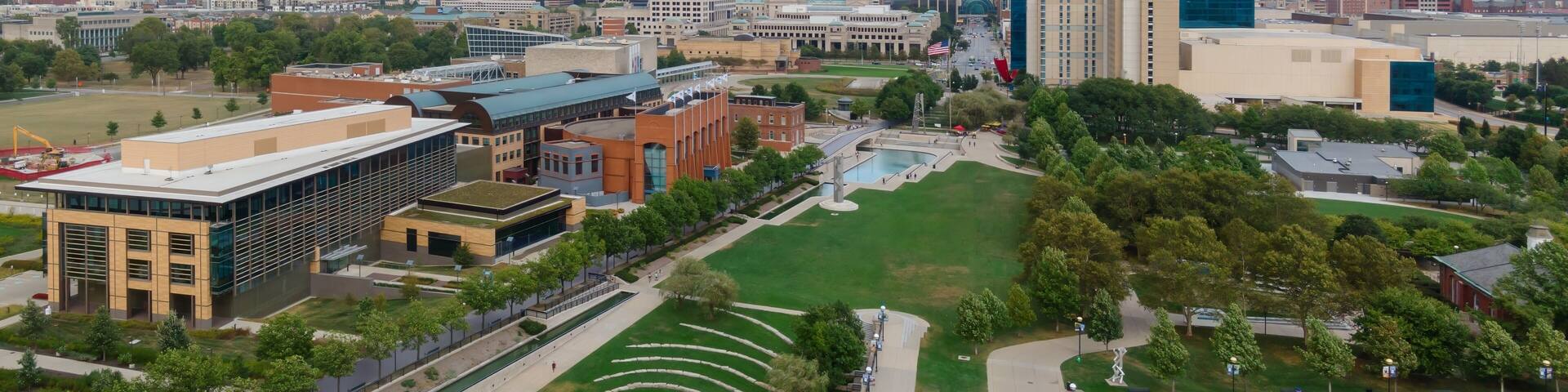 High-angle view of downtown Indianapolis, IN. Parks, buildings, and the White River are visible. People are walking and relaxing. Downtown, Indianapolis, Indiana, United States