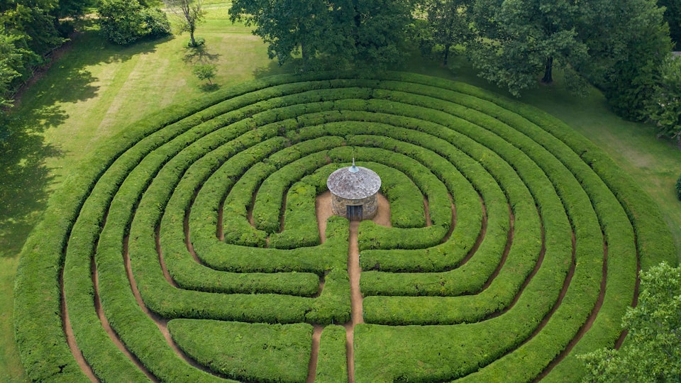 A large, circular maze garden with a central gazebo.