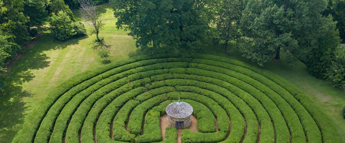 A large, circular maze garden with a central gazebo.