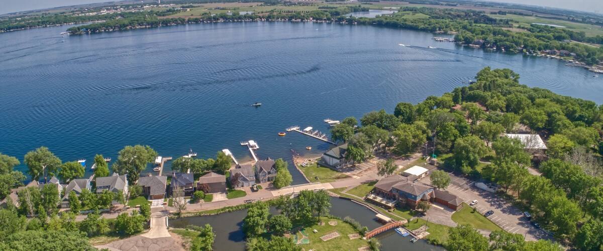 A lakeside community with boats, docks, and residential houses.