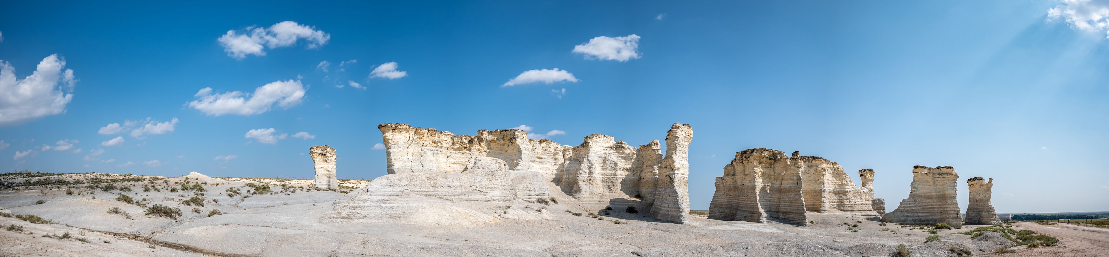 A landscape with tall, eroded rock formations under a clear blue sky.