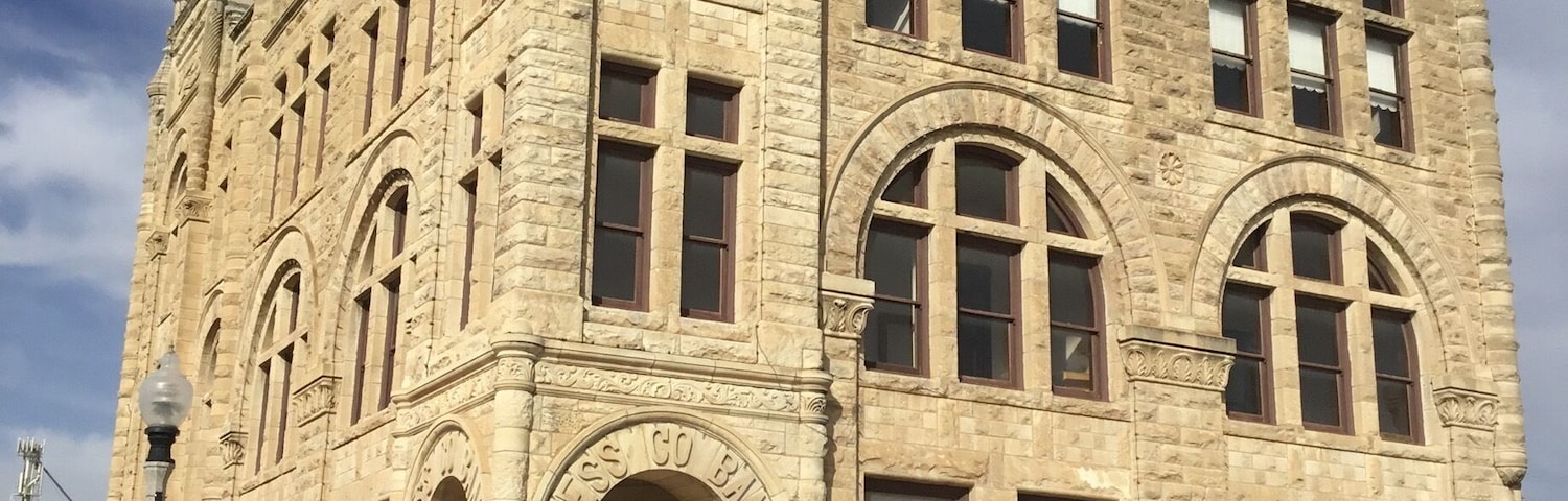 It says Ness Co Bank over he door of this grand stone building in a pretty small town in western KS.