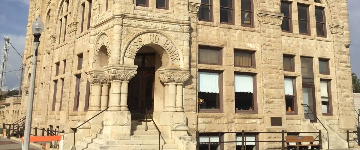 A historic stone building with arched windows and a prominent entrance.