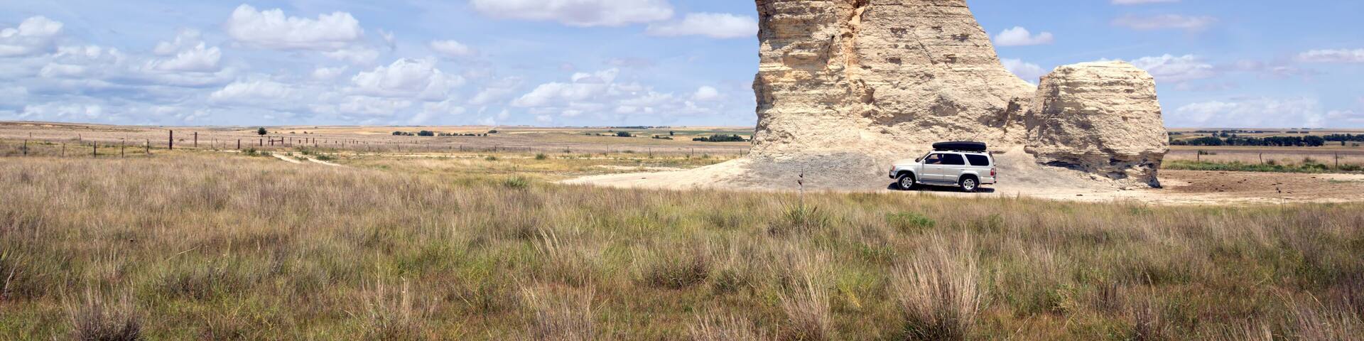 A landscape with rock formations and a vehicle.