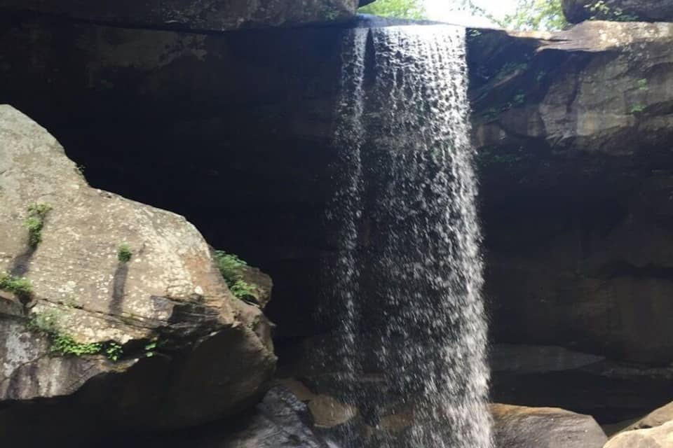 A waterfall cascading over rocks in a forested area.