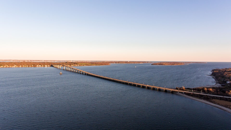 A long bridge spanning a wide river with a clear sky.