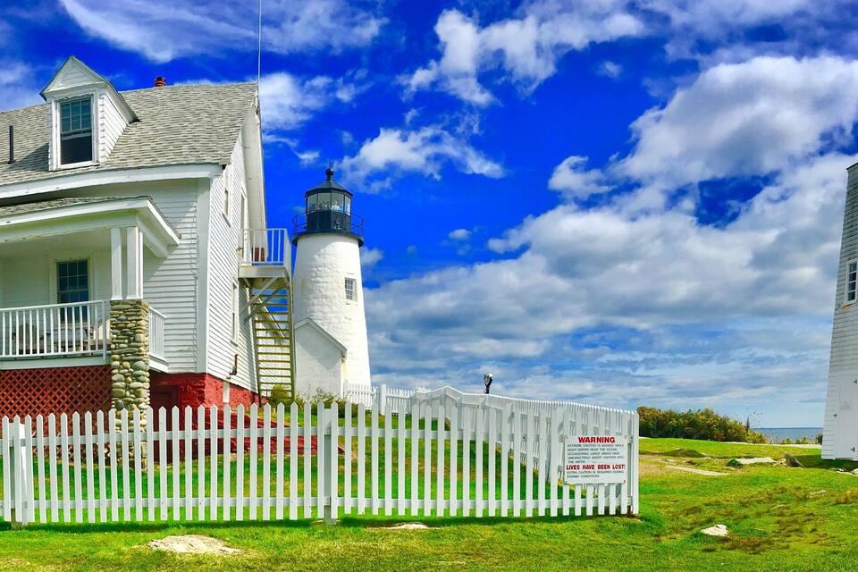 Une maison blanche avec un phare et une tour.