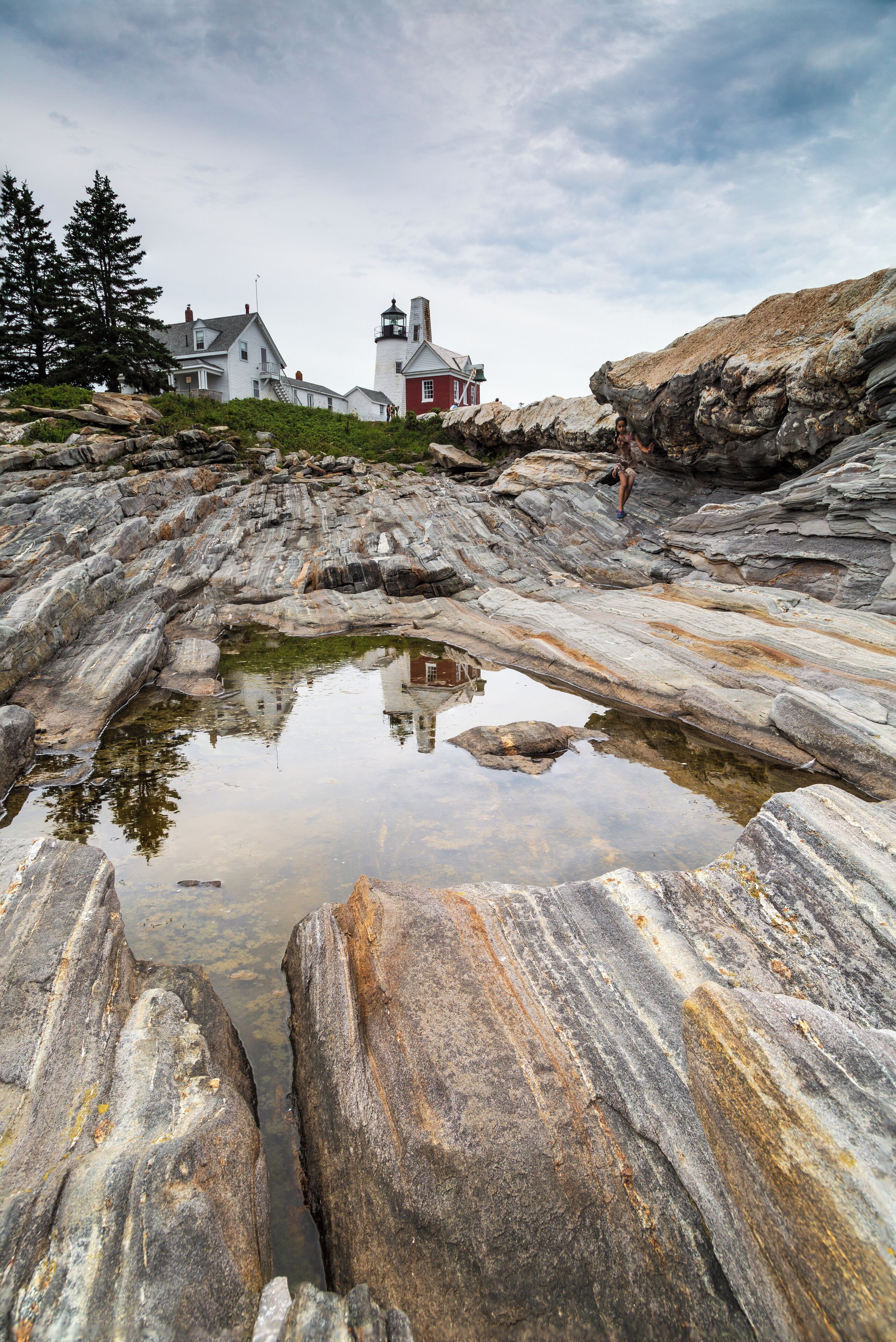 Focus-stacked image (4 images) taken from the rocks surround Pemaquid Point Light.  I was intrigued by the striations on the rocks that point at the subject of the picture reflected in the shallow pool.  Low, wide angle.