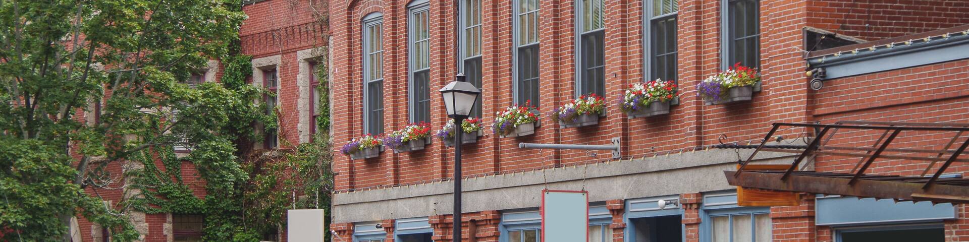 Picturesque cityscape skyline view of Portland, Maine with yacht marina, sailing boats, historic building facades, streets and urban living coast fisher atmosphere