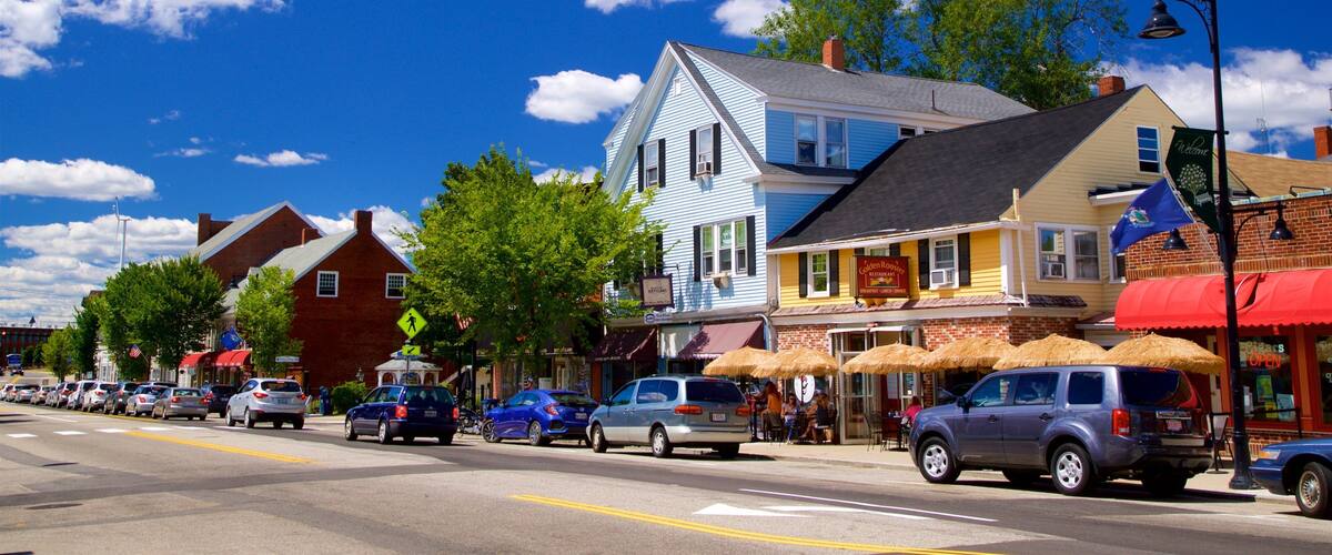 A street lined with colorful buildings, a clear blue sky, and parked cars.