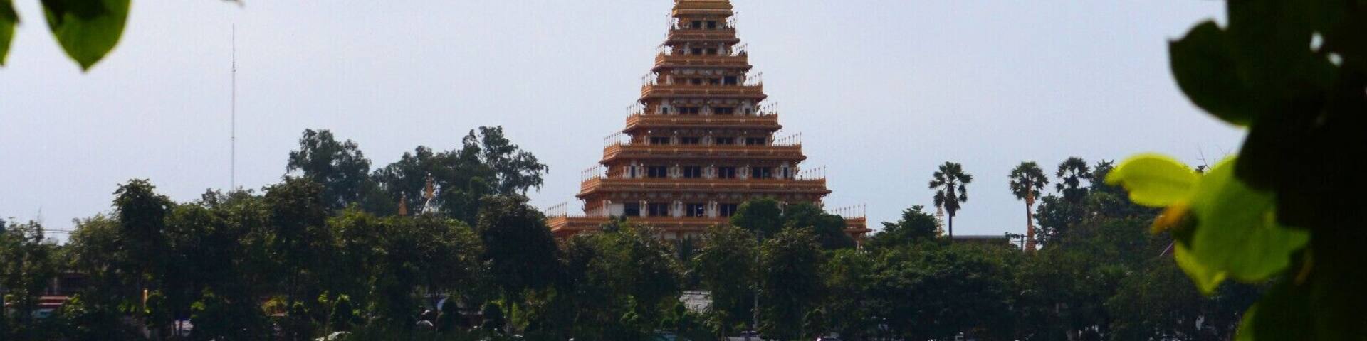 A pagoda-like structure with multiple tiers, surrounded by trees and a body of water.