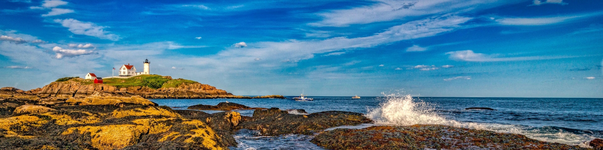 Um farol sobre um afloramento rochoso, com o oceano ao fundo.