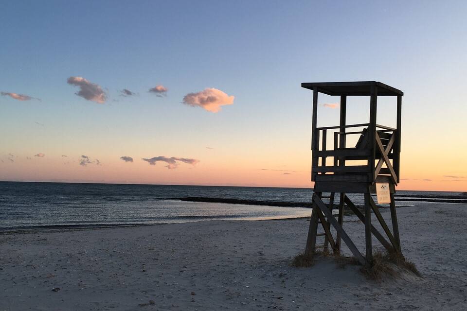 A lifeguard tower on a beach at sunset.