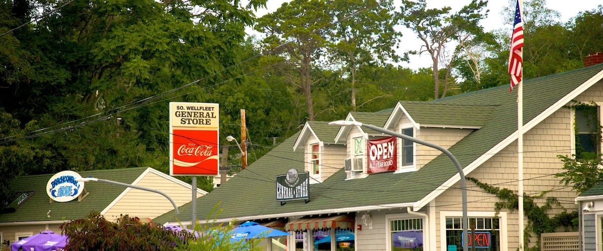 A general store with an American flag, Coca-Cola sign, and a beachcomber store sign.