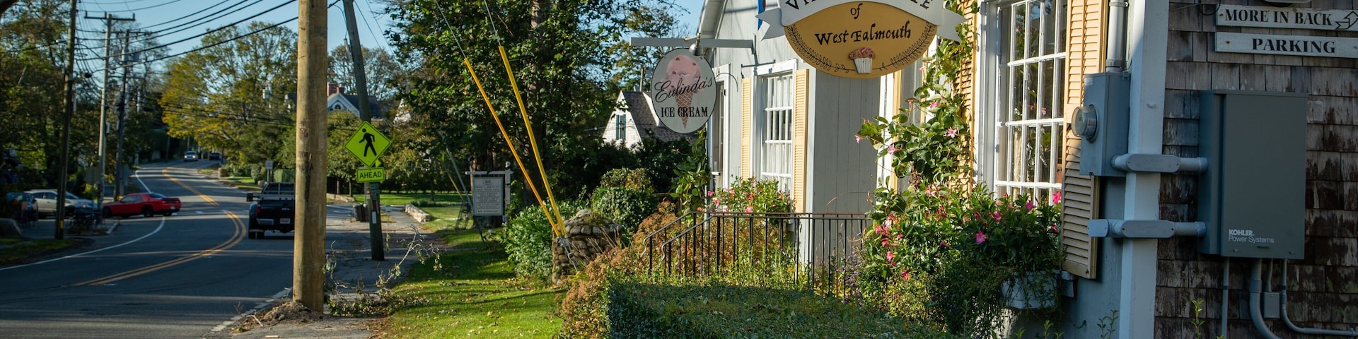 A village cafe with a sign reading "Village Cafe of West Falmouth" and "Ellinda's Ice Cream".