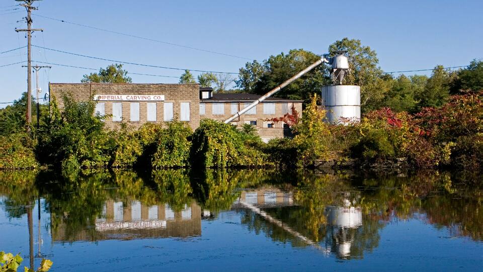 A building labeled "Imperial Carving Co." with a silo and a crane in a flooded area.
