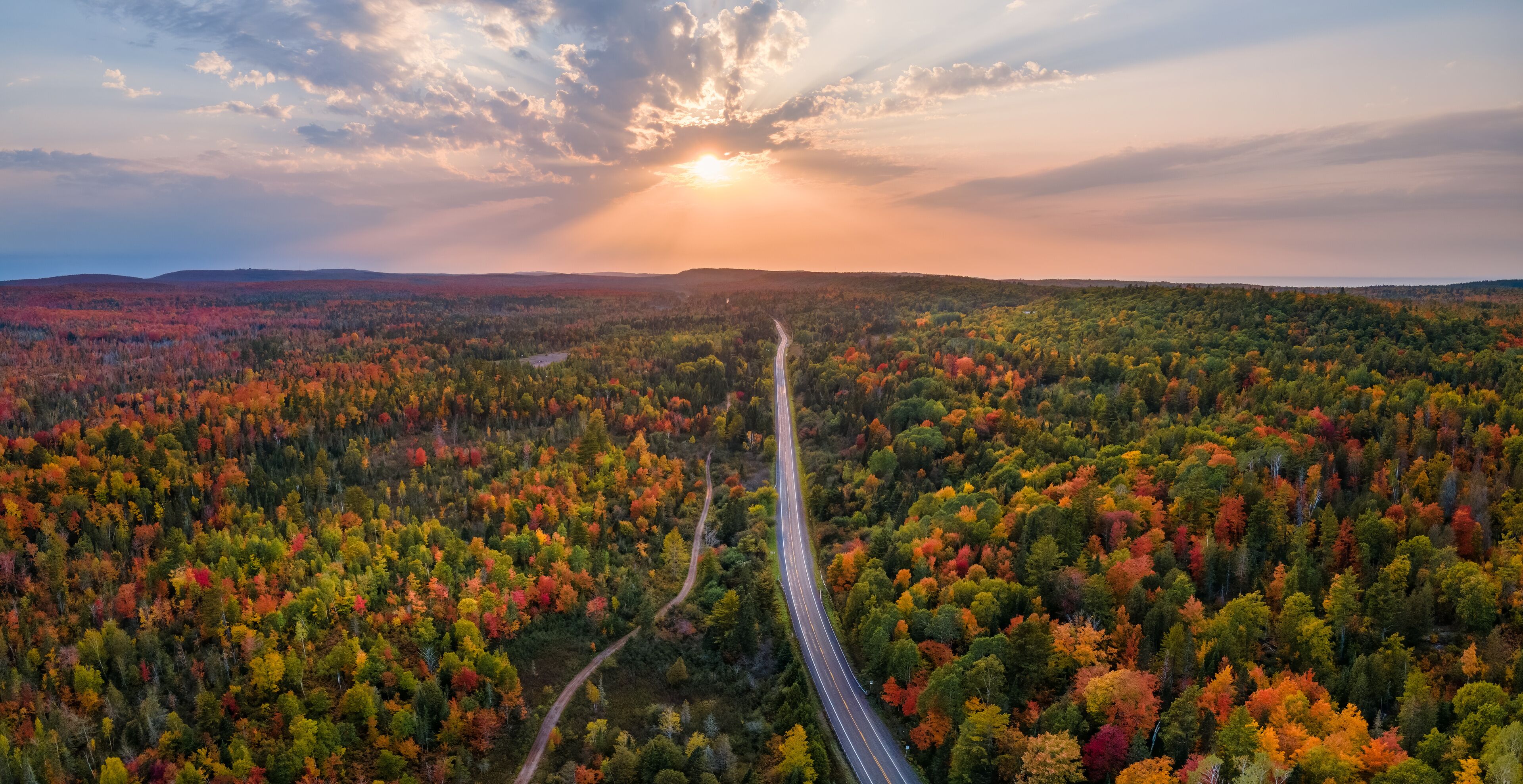 Sunset Autumn drive through the tunnel of Trees in Michigan Upper Peninsula UP - Highway 41  M26 Aerial view