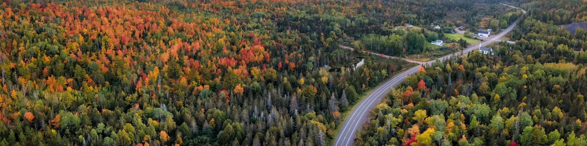 Sunset Autumn drive through the tunnel of Trees in Michigan Upper Peninsula UP - Highway 41 M26 Aerial view