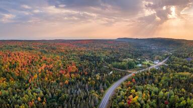 Sunset Autumn drive through the tunnel of Trees in Michigan Upper Peninsula UP - Highway 41 M26 Aerial view