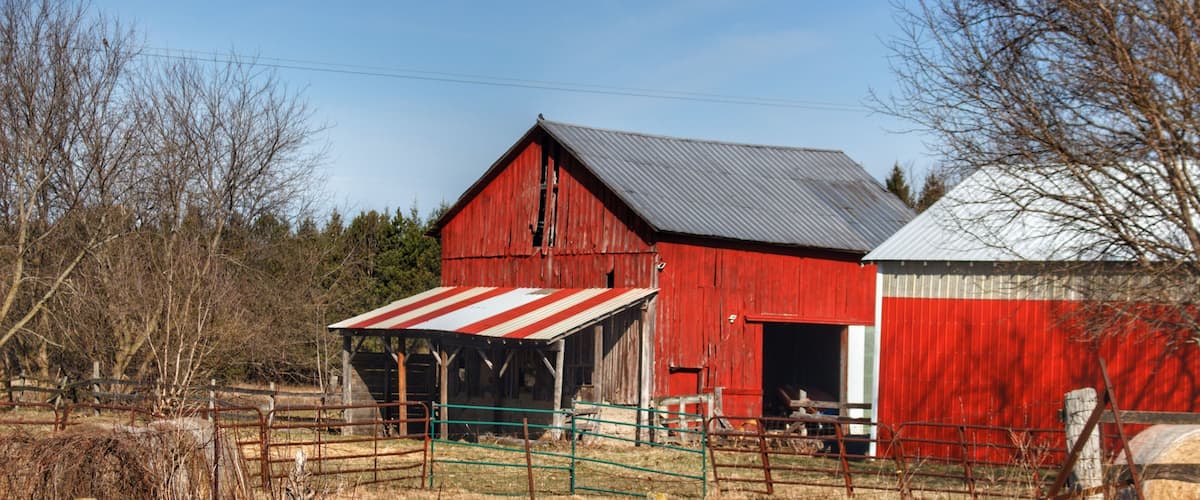 A red barn with a metal roof and a smaller adjacent building.