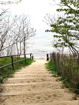 A nice sand covered walkway to the beach at Lake Michigan at Piers Cove Park.
A small, beautiful beach, Fennville’s Pier Cove Beach features a small creek that lets out into Lake Michigan, which is often warmer than the big lake. It’s perfect for small kids to splash in! Families can also find rocks and logs and make sculptures! In the big lake, kids (and adults!) will swim to their hearts’ content. Oh, and dogs are welcome! This is the perfect pit stop to escape crowds; the only drawback: there are no bathrooms or changing rooms, so plan accordingly!