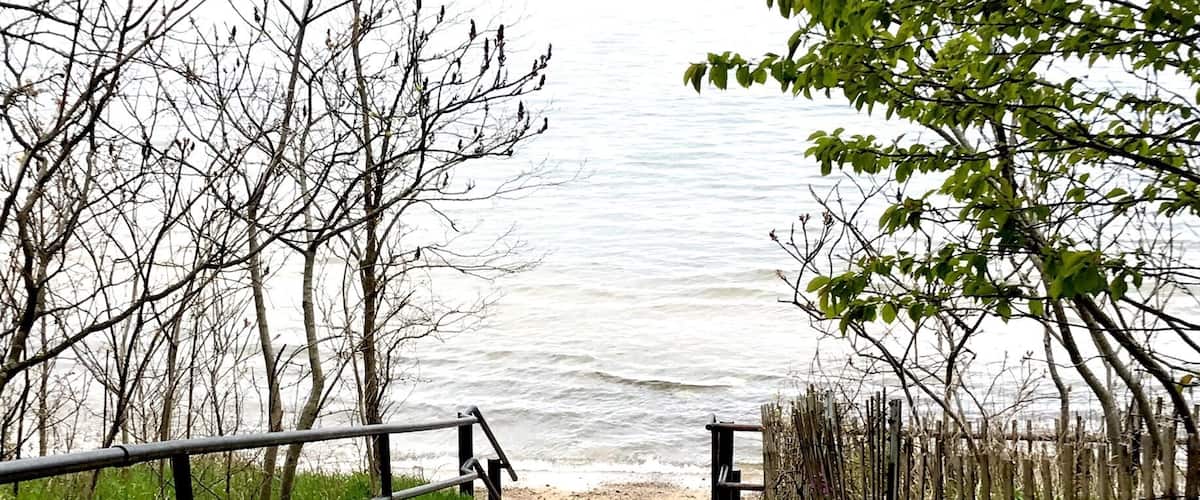 A nice sand covered walkway to the beach at Lake Michigan at Piers Cove Park.
A small, beautiful beach, Fennville’s Pier Cove Beach features a small creek that lets out into Lake Michigan, which is often warmer than the big lake. It’s perfect for small kids to splash in! Families can also find rocks and logs and make sculptures! In the big lake, kids (and adults!) will swim to their hearts’ content. Oh, and dogs are welcome! This is the perfect pit stop to escape crowds; the only drawback: there are no bathrooms or changing rooms, so plan accordingly!