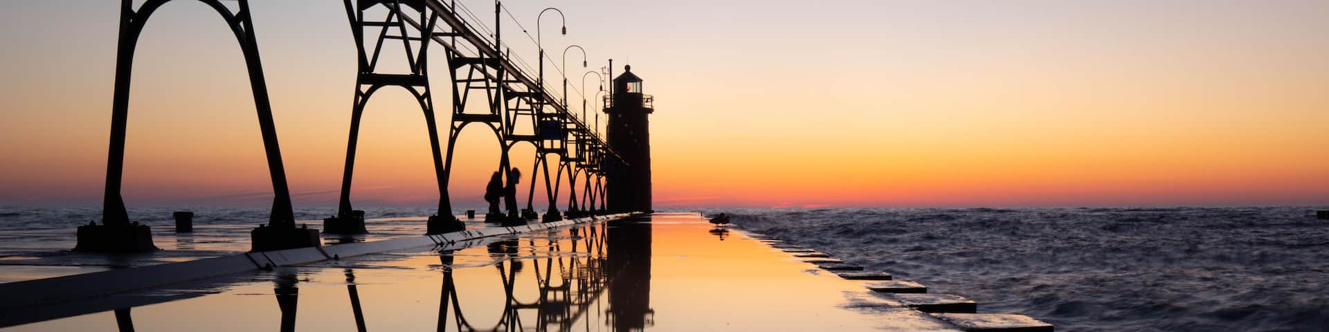 Lighthouse at beautiful sunset, symmetric mirror reflection, South Haven Lake Michigan