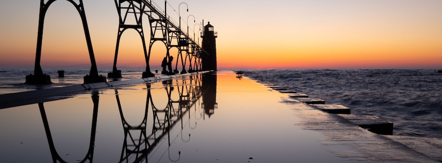 Lighthouse at beautiful sunset, symmetric mirror reflection, South Haven Lake Michigan