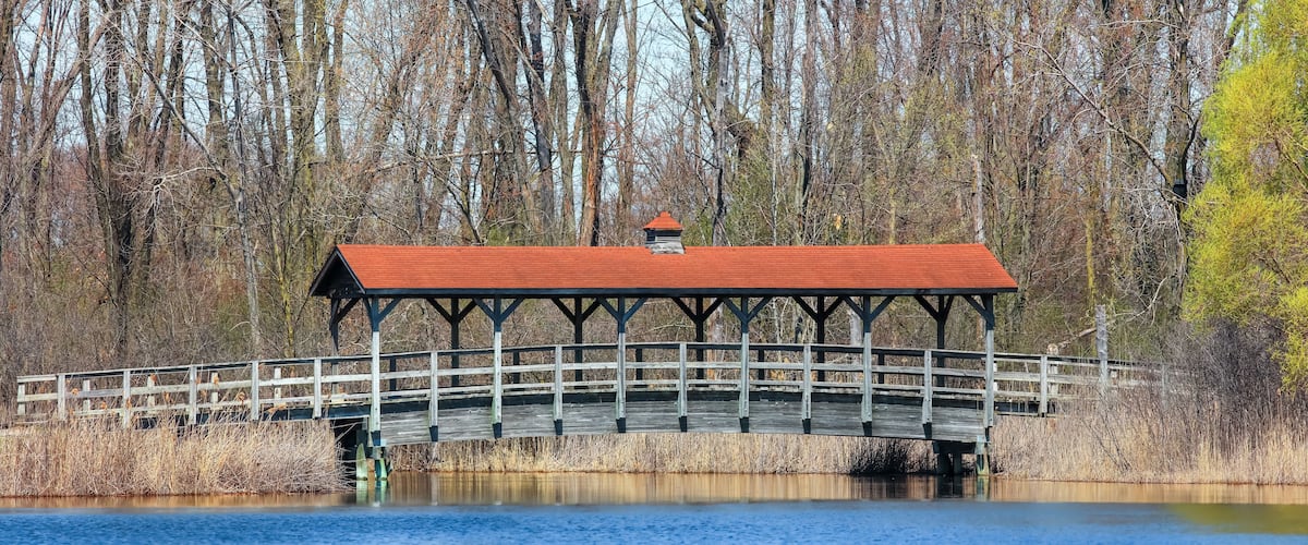 Historic covered bridge in Michigan over the creek during early spring time