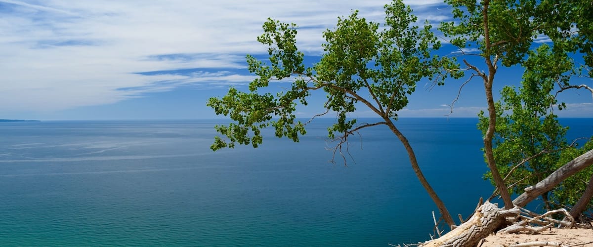 A view of Lake Michigan along the Pierce-Stocking Scenic Drive in  Sleeping Bear Dunes National Lakeshore. The water is such a beautiful blue, with greens and teals nearer the shore. You can hike the dunes to the beach below, but be forewarned, the dunes are 2,000 feet high. It takes hours to climb back up, and often people have to be rescued because they can’t make the climb. #blue #green #AquaTrove #BVSBlue #AboveItAll