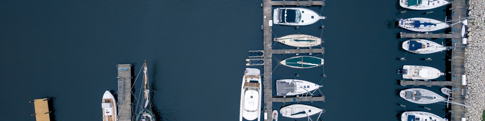 Un puerto deportivo con varias embarcaciones amarradas a muelles de madera.