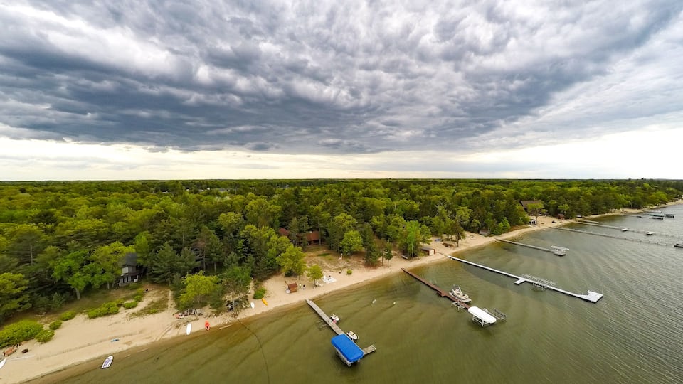 A river with boats, a dock, and a forested area.