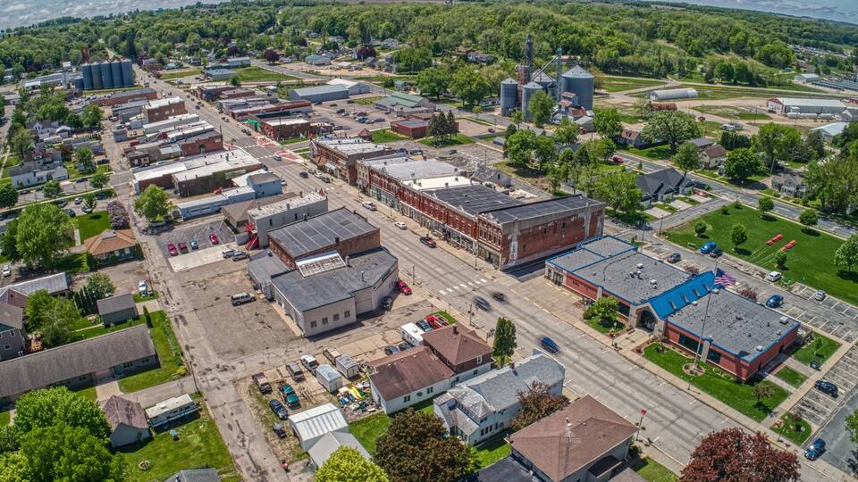 An aerial view of a town with industrial buildings, roads, and green areas.
