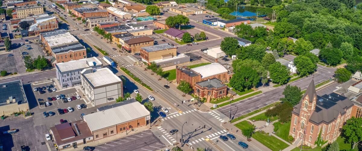 An aerial view of a town with a river, green parks, and historic buildings.