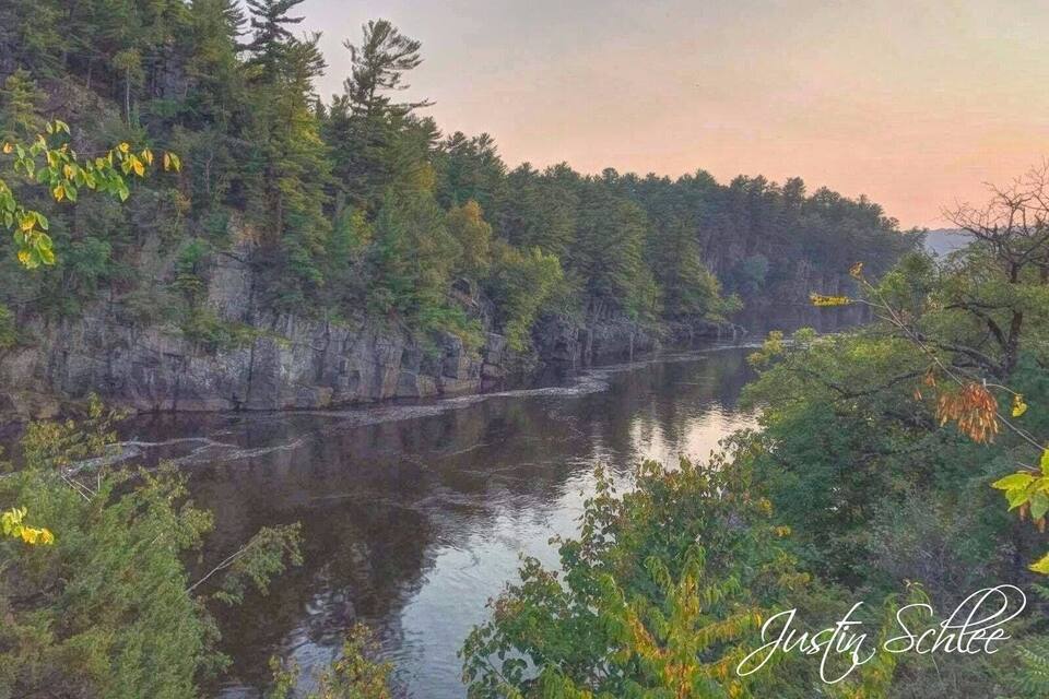 A river surrounded by dense forest and rocky cliffs.