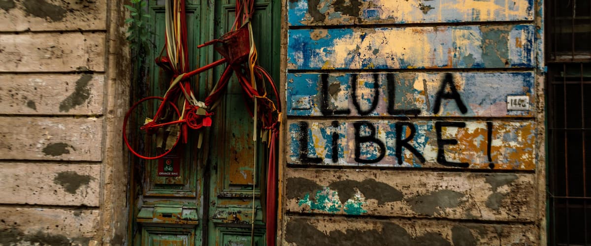 A weathered building with a green door and a sign reading "LULA LIBRE".