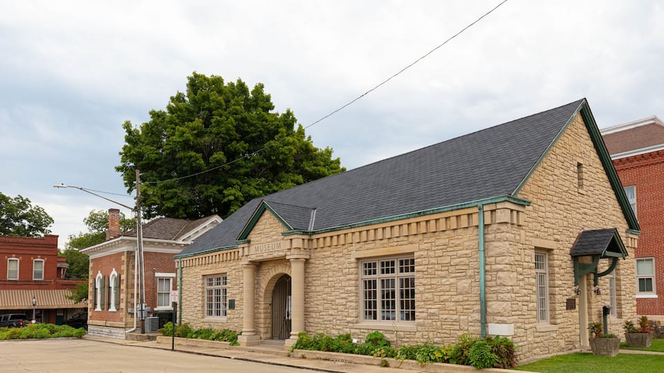 A stone building with a green roof and a sign that reads 'Museum.'