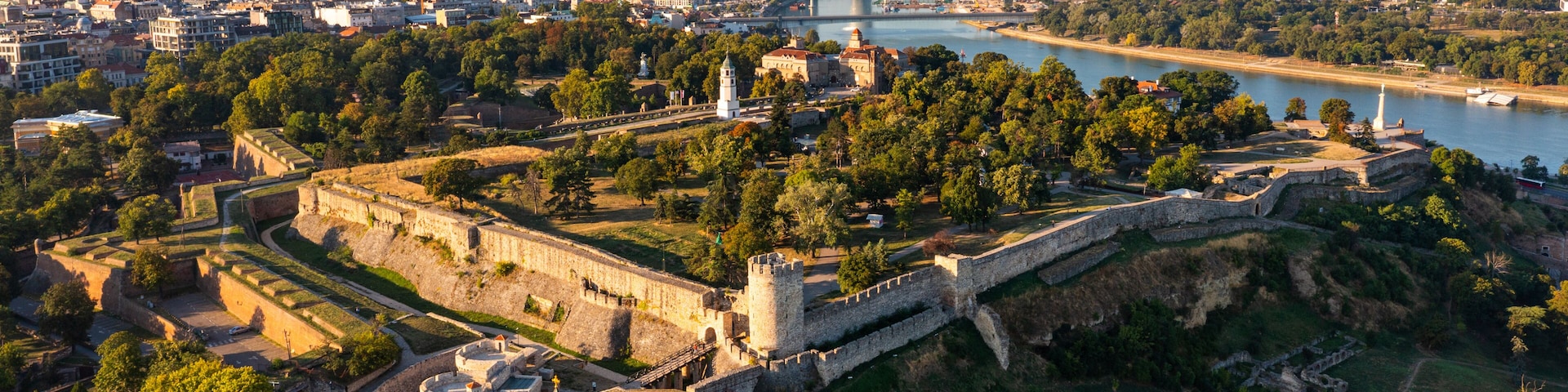 Aerial panoramic image of preserved defensive walls and fortified towers of Kalemegdan Fortress located at confluence of Danube and Sava rivers in Belgrade, facing modern city in early autumn