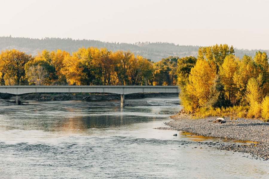 Bridge over Yellowstone River with yellow autumn trees