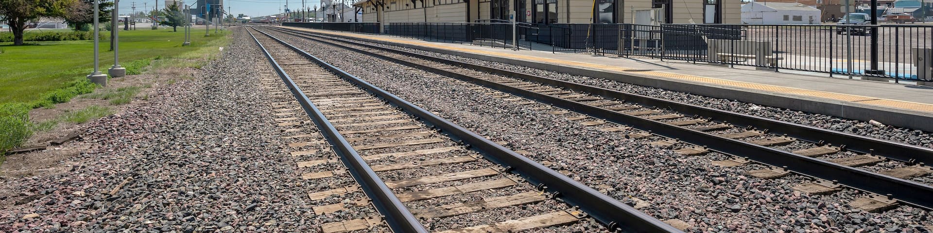 A railway station with multiple tracks and a building labeled "CUT BANK".